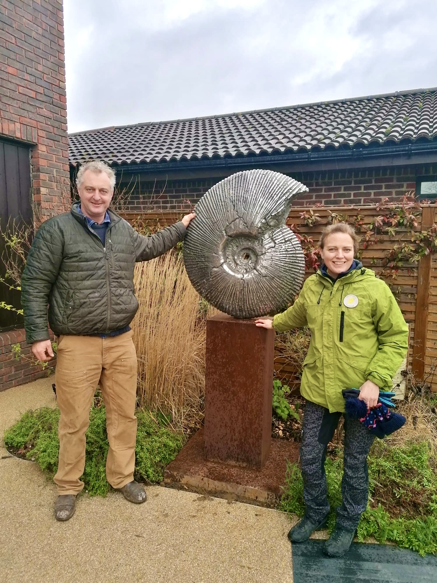 Hamish Mackie with Head Gardener Amy installing Ammonite sculpture